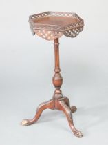 An Edwardian hexagonal Chippendale style wine table with pierced fret, raised on turned column and