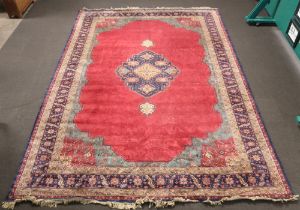 A red, blue and green ground Persian carpet with central medallion within a multi row border 187cm x