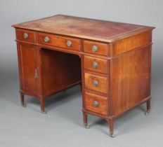 An Edwardian mahogany desk with inset red leather writing surface fitted a long frieze drawer, 1