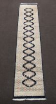 A blue, white and pink ground Bokhara runner with 13 diamonds to the centre 233cm x 64cm Fringe