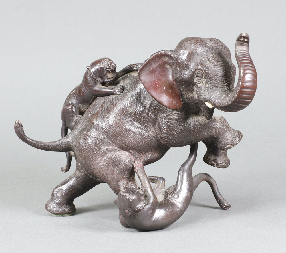 A Japanese Meiji bronze of an elephant encountering tigers 15cm x 22cm x 10cm, the base with seal