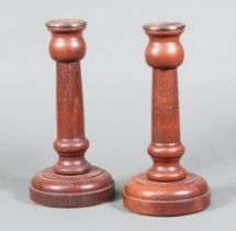 A pair of 1920's turned oak candlesticks with plated sconces on circular bases 23cm, base marked