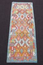 A yellow and turquoise ground Chobi Kilim runner with all over geometric design 240cm x 83cm