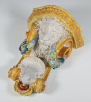 A Continental ceramic wall bracket with a lion mask shell and swags of flowers 32cm There are