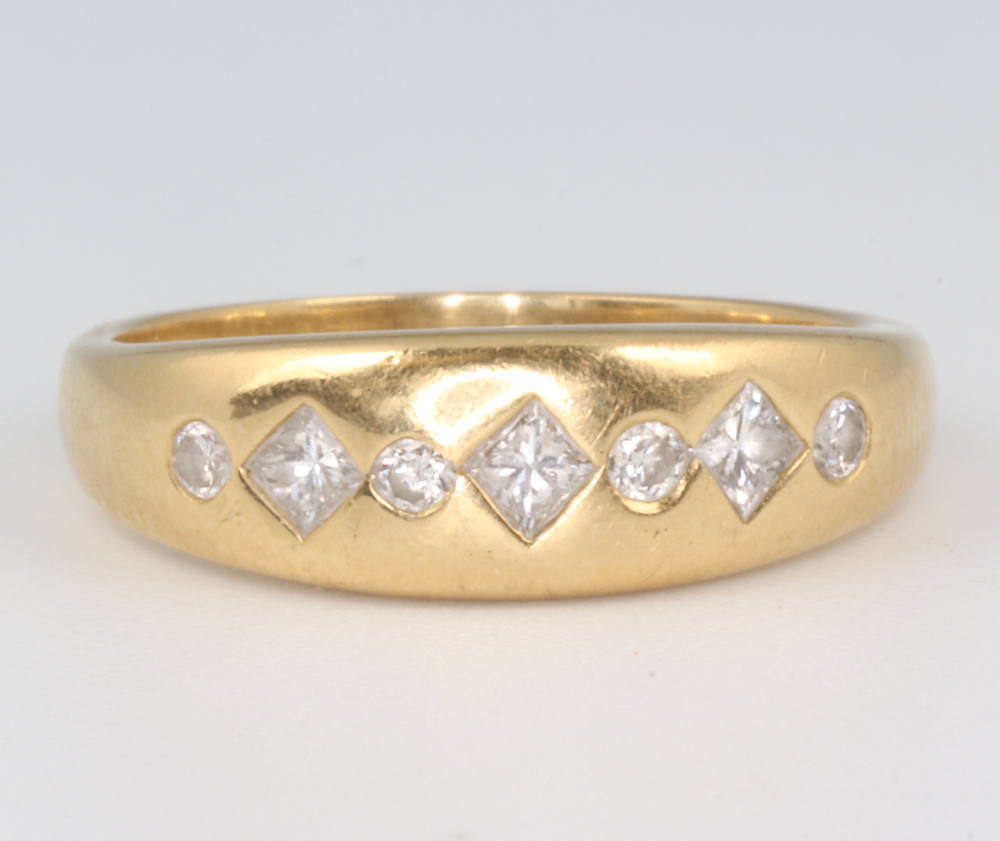 An 18ct yellow gold gypsy ring set 4 brilliant diamonds and 3 princess cut diamonds, 4.3 grams,