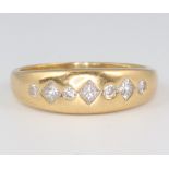An 18ct yellow gold gypsy ring set 4 brilliant diamonds and 3 princess cut diamonds, 4.3 grams,