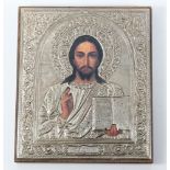 A 20th Century icon showing a print of Christ in a white metal repousse oklad 14cm x 12cm