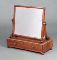 A William IV rectangular plate dressing table mirror contained in a mahogany swing frame, base