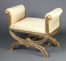 A 19th Century style carved and gilt painted window seat with X frame, upholstered in yellow