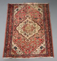 An Afghan red and white ground rug with central medallion 140cm x 107cm In wear