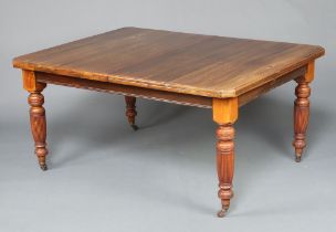 A Victorian walnut extending dining table raised on turned and reeded supports 74cm h x 152cm w x