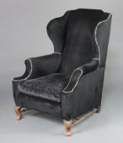 A Georgian style winged armchair upholstered in black material raised on cabriole supports with H