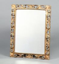 A rectangular plate mirror contained in a carved pierced gilt wood frame 73cm h x 56cm d