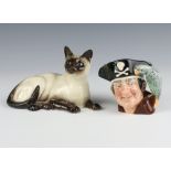 A Royal Doulton reclining Siamese cat 1559 17cm, ditto character jug Long John Silver 10cm