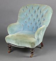 A Victorian armchair upholstered in blue buttoned material raised on turned supports, ceramic