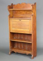 An Edwardian Art Nouveau Liberty style student's bureau with raised back fitted 2 shelves above a