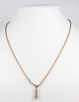 A 9ct yellow gold necklace 36cm with a graduated 3 stone diamond pendant set in yellow metal 0.15ct,