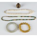 A hardstone bangle (a/f) and 3 others and a snuff bottle