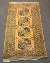 An orange and black ground Afghan rug with 4 octagons to the centre 214cm x 119cm Slight staining