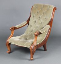 A Victorian carved mahogany show frame armchair upholstered in green buttoned material, raised on