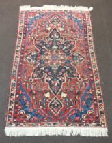 A blue, white and red ground Persian rug with central medallion 201cm x 117cm In wear, flecking