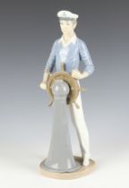 A Lladro figure of a sailor standing at a ships wheel 5206 33cm