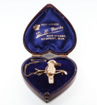 An Edwardian yellow metal 9ct ruby and seed pearl brooch in the form of a bird sitting on a branch