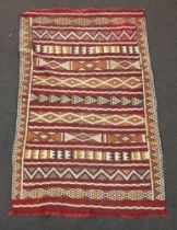 A black, tan and white ground Kilim rug with geometric designs 161cm x 101cm