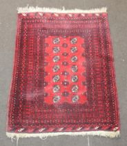 A red and black ground Afghan rug with 14 octagons to the centre within a multi row border 135cm x