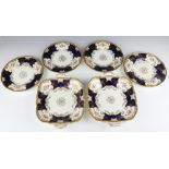 Four Edwardian Coalport dessert plates decorated with spring flowers, together with a pair of