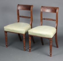 A pair of Georgian mahogany bar back dining chairs with spiral turned mid rails and over stuffed