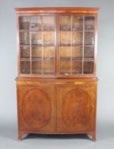 Heal's, a Georgian style bow front display cabinet on cabinet with moulded cornice, the