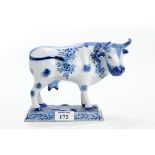 A DUTCH DELFT BLUE & WHITE COW, floral decorated on a rectangular base, 16.5cm high. £25-£40.