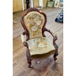 A VICTORIAN WALNUT SHOW-WOOD FRAME ARMCHAIR upholstered in floral tapestry, carved open arms,