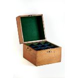 A LATE 19TH CENTURY OAK TRAVELLING DECANTER BOX, the hinged lid revealing nine apertures,