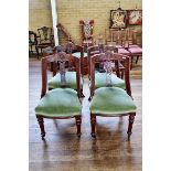 A SET OF FOUR LATE VICTORIAN MAHOGANY DINING CHAIRS with shaped carved back, stuff-over seats,
