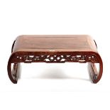 A CHINESE HARDWOOD SCROLL ENDED LOW TABLE with pierced dragon motif frieze, 87 cms x 45cms.