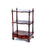 A VICTORIAN MAHOGANY SERPENTINE FRONTED MAHOGANY THREE-TIER WHATNOT raised on spiral grooved