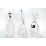 THREE VARIOUS IRISH WATERFORD CRYSTAL DECANTERS & STOPPER, one with a silver spirit label. (4).