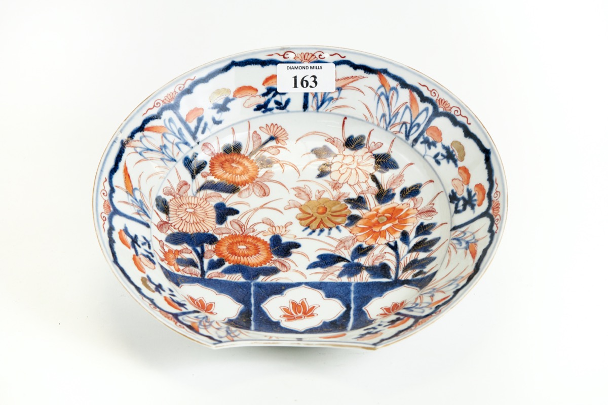 AN 18TH CENTURY ORIENTAL ARITA STYLE PORCELAIN BARBER'S BOWL floral decorated in underglaze blue &