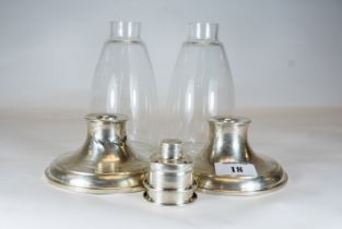 A pair of sterling silver storm lights, glass shades, on sterling silver bases, loaded, 24cms