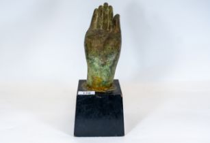 An antique bronze hand of Buddha, on an ebonized wooden plinth, 31cms, £150 - £250