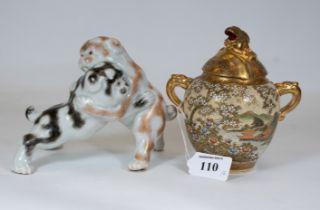 An unusual Japanese Kutani porcelain group of two puppies at play in a sumo style pose, 14cms high