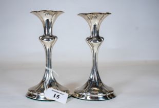 A pair of Edwardian Art Nouveau silver candlesticks on shaped oval bases, maker: -SBS. LTD, Chester