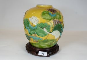 A 19th century chinese porcelain vase, mustard ground with raised decoration of a wading crane