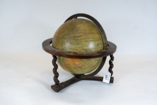 A 1930s French Terrestrial globe with brass meridian on a barley twist oak stand, illuminated
