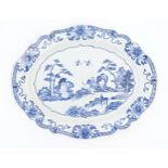 A Chinese blue and white plate of oval form with a shaped rim, decorated with a figure in a rocky