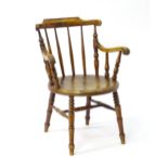 An early Victorian penny seated Windsor chair, having a bowed top rail and turned spindle back
