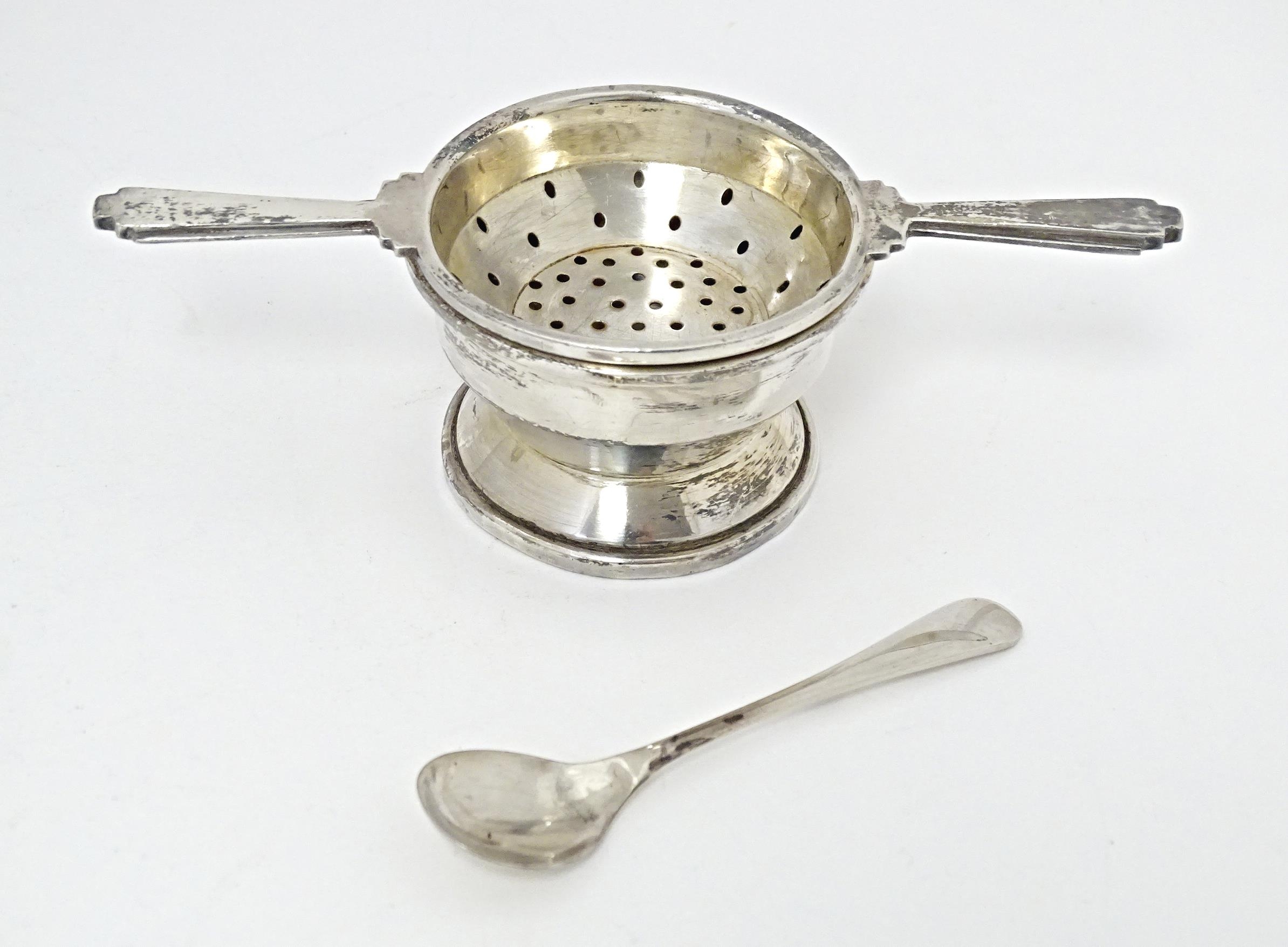 An Art Deco style silver twin handled tea / lemon strainer with stand hallmarked Birmingham 1960,