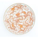 A Chinese plate decorated with five dragons amongst stylised clouds with a gilt flaming pearl.